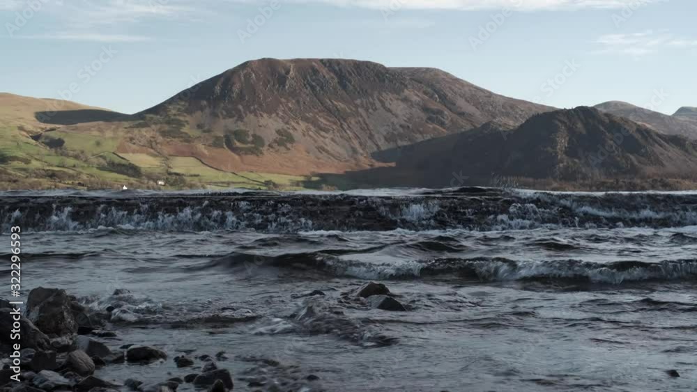 Winter winds blow across the surface of Ennerdale Water in the Lake District, Cumbria, England with sunshine on the hills beyond. Winter winds blow across the surface of Ennerdale Water in the Lake District, Cumbria, England with sunshine on the hills beyond.