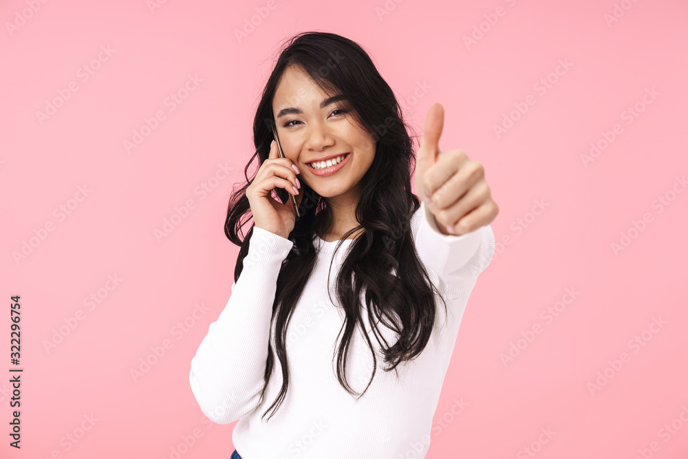 Image of young brunette asian woman with long hair talking on cellphone Image of young brunette asian woman with long hair talking on cellphone