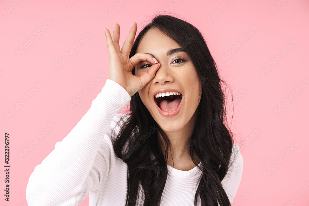 Image of young brunette asian woman smiling and gesturing ok sign Image of young brunette asian woman smiling and gesturing ok sign
