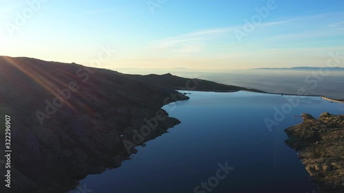 Aerial, pan, drone shot, overlooking the lake Lagoa Comprida, Maques da silva dam and rocky nature, at sunset, Serra da Estrela, Guarda, Portugal