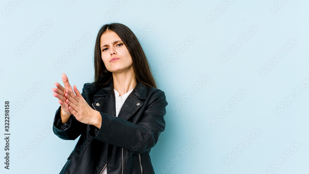 Young caucasian woman isolated on blue background feeling energetic and comfortable, rubbing hands confident.