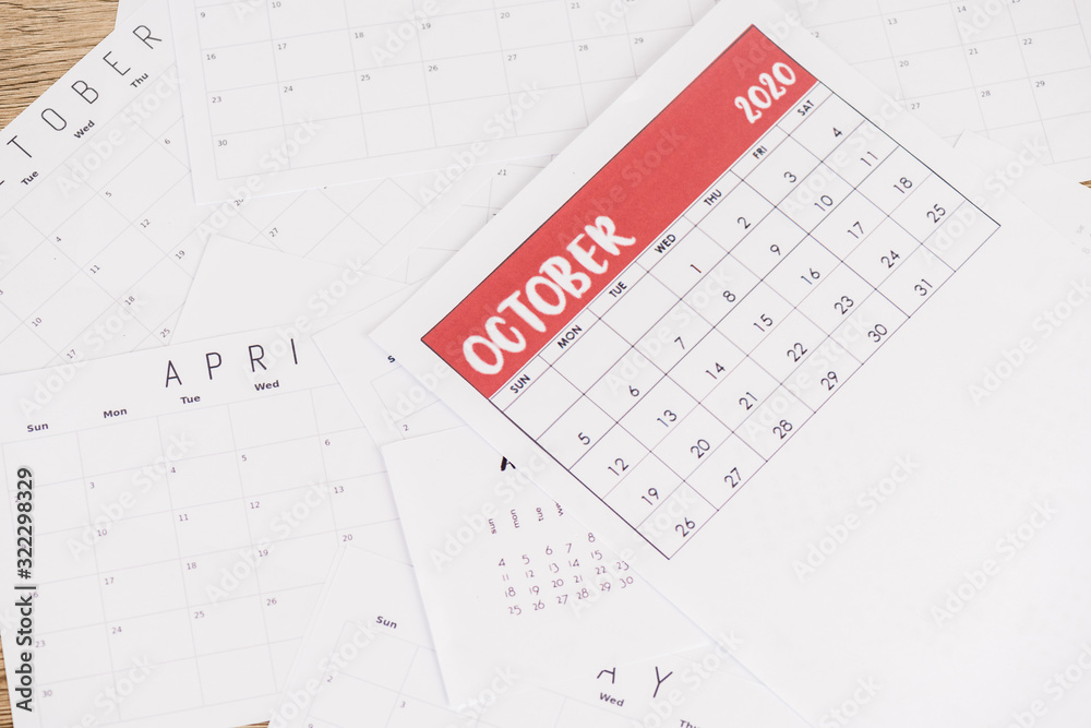 Top view of paper monthly calendars on wooden background Top view of paper monthly calendars on wooden background