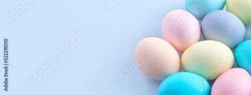 Colorful Easter eggs dyed by colored water isolated on a pale blue background  design concept of Easter holiday activity  close up  copy space.