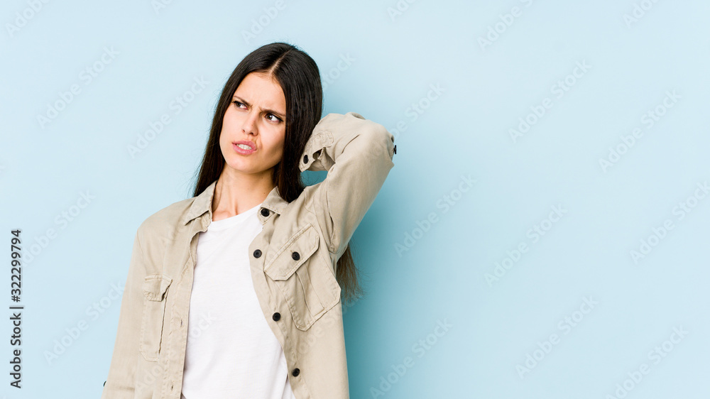Young caucasian woman isolated on blue background suffering neck pain due to sedentary lifestyle. Young caucasian woman isolated on blue background suffering neck pain due to sedentary lifestyle.