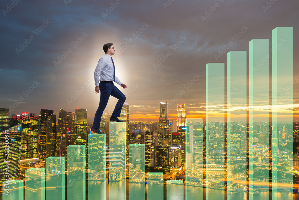 Businessman climbing bar charts in growth concept