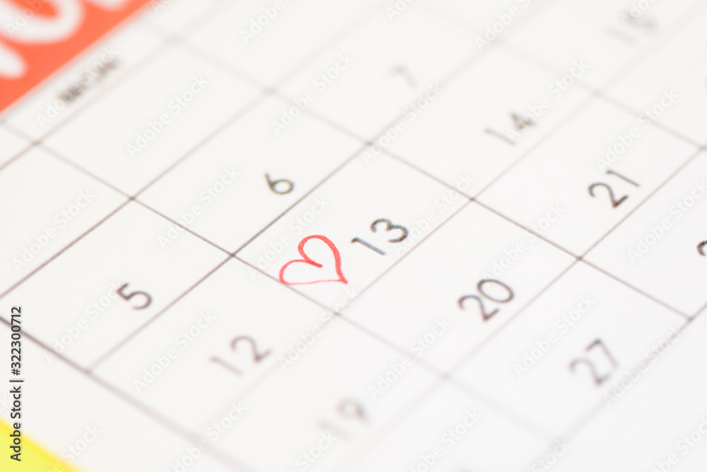 Selective focus of calendar with heart sign on yellow background Selective focus of calendar with heart sign on yellow background