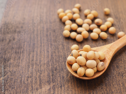 Soybeans in wooden spoon on table, Protein plant health food.