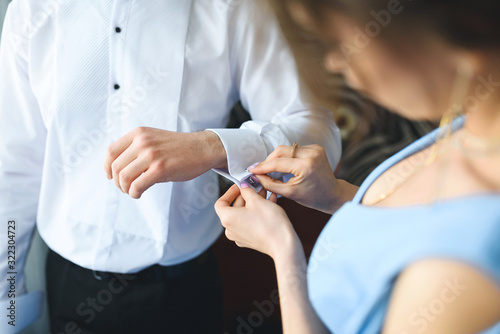 woman helping man with sleeve links