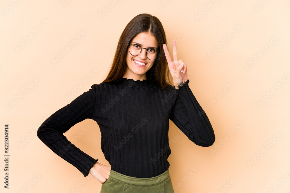 Young caucasian woman isolated on beige background showing number two with fingers. Young caucasian woman isolated on beige background showing number two with fingers.