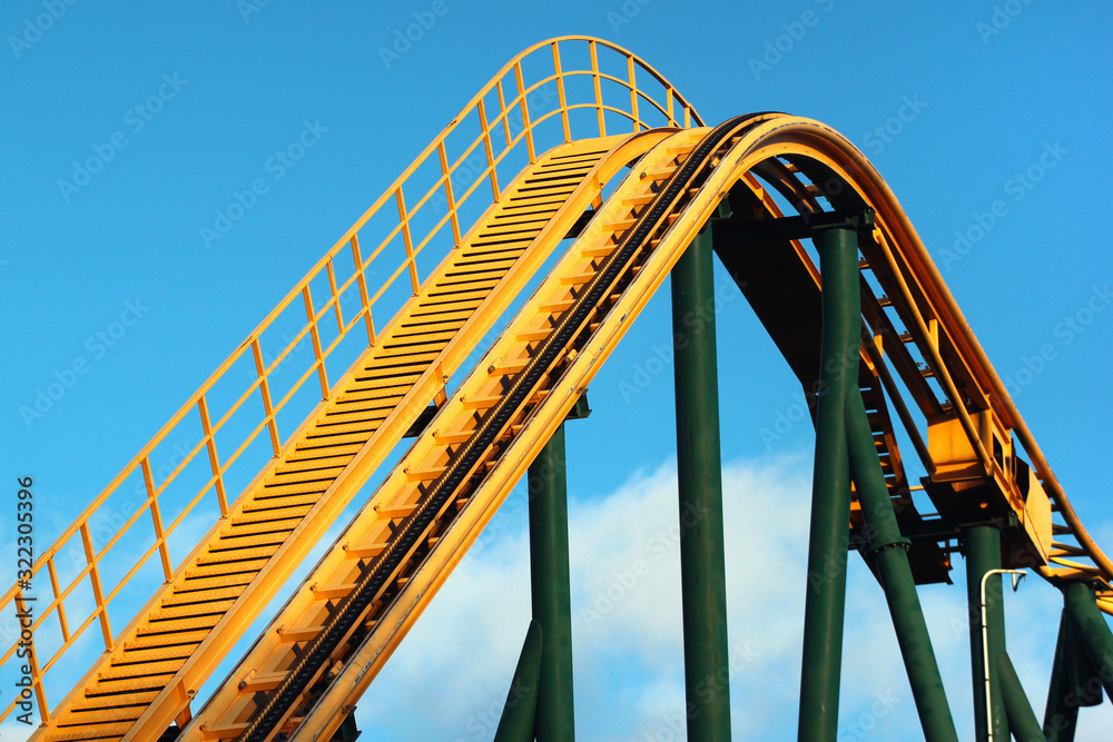 Roller coaster against blue sky background. Amusement park attractions. Roller coaster against blue sky background. Amusement park attractions.