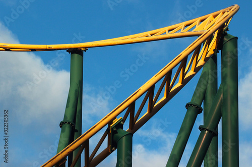 Roller coaster against blue sky background. Amusement park attractions.