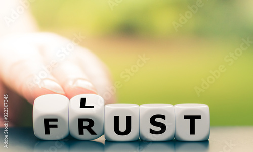 Obraz na plátně Hand turns dice and changes the German word Frust (frustration) to Lust (Lust in English)