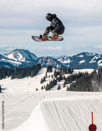 Fotografie Snowboard riding through terrain park