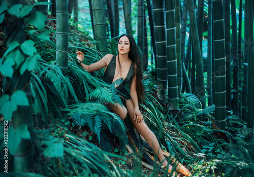 Princess resting bamboo forest green nature fern grass grove botanical garden tropics silence healthy long hair brunette. nymph sexy creative emerald fashion dress. summer spring Georgia fantasy art  photo