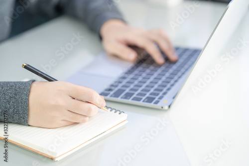 Woman working at home office using laptop searching web, browsing information