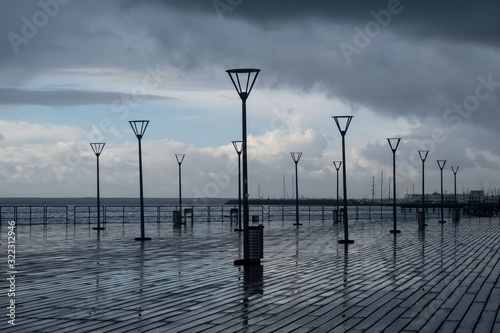 Lanterns on the embankment after rain and cloudy sky