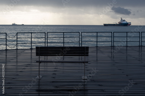 Promenade benches after rain and cloudy sky