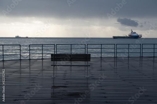 Promenade benches after rain and cloudy sky