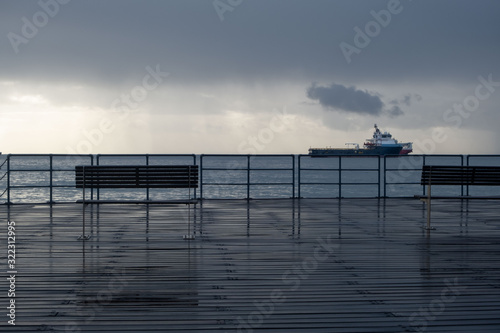 Promenade benches after rain and cloudy sky