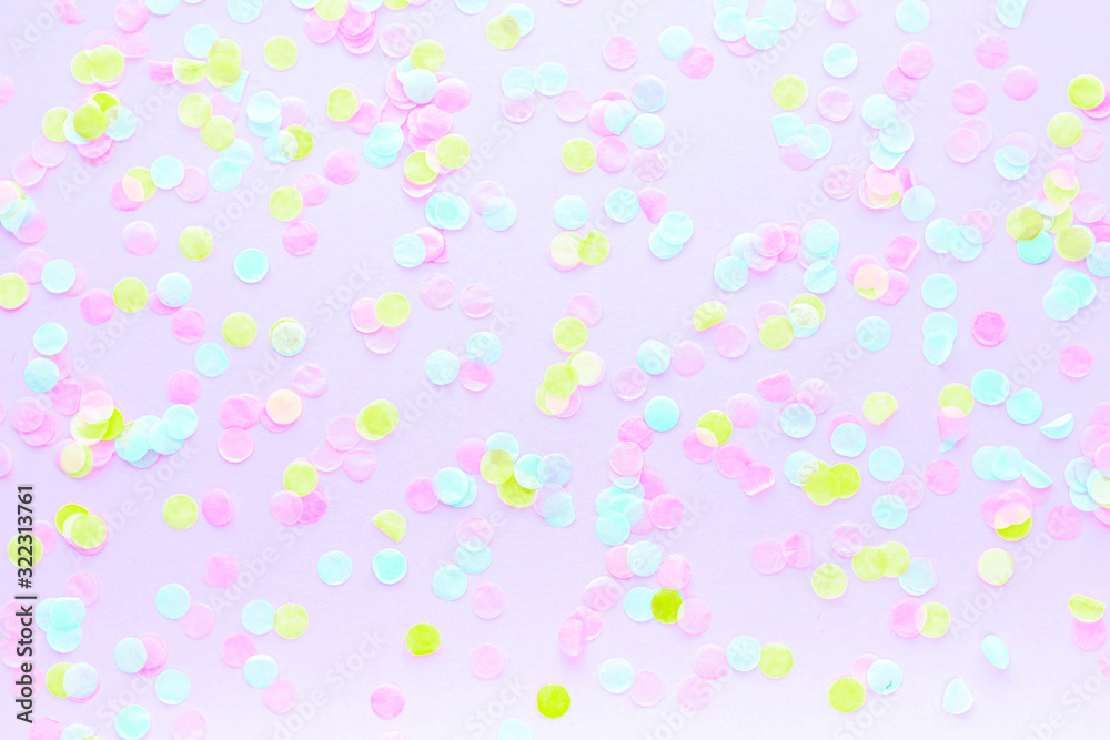 Festive abstract background for the design. Colorful confetti on a pink background. Top view, flat lay, layout. Copy space for text.
