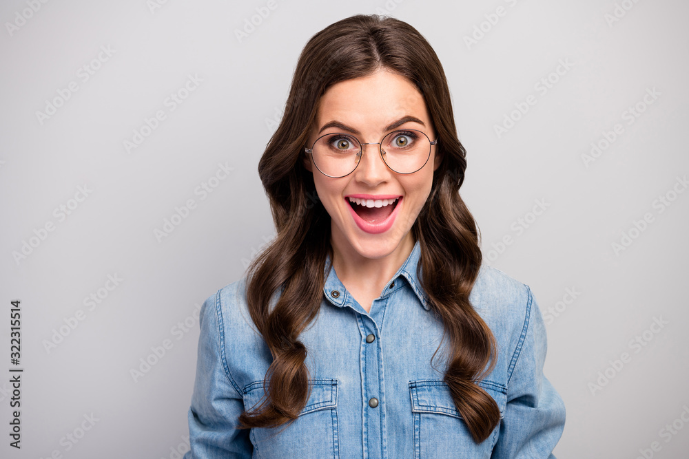 Closeup photo of pretty excited business lady open mouth listen positive good mood long curly hairdo wear specs casual jeans shirt isolated grey color background Closeup photo of pretty excited business lady open mouth listen positive good mood long curly hairdo wear specs casual jeans shirt isolated grey color background