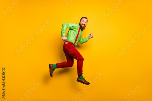 Full size photo of cheerful irish man jump run after discount wear good look clothing suspendsers trousers shoes isolated over bright color background © deagreez