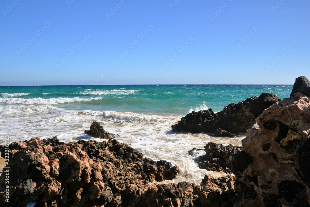Beautiful Atlantic ocean shore with rocks and strong waves. Seaside scenery of south-east coast of Fuerteventura, Canary Islands, Spain
