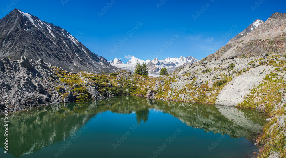 Picturesque mountain lake on a sunny day. Beautiful reflection, panoramic view. Summer rest.