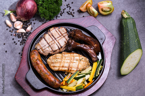 grilled sausages and ribs with potatoes and vegetables