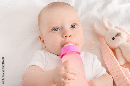 Adorable baby girl drinking...