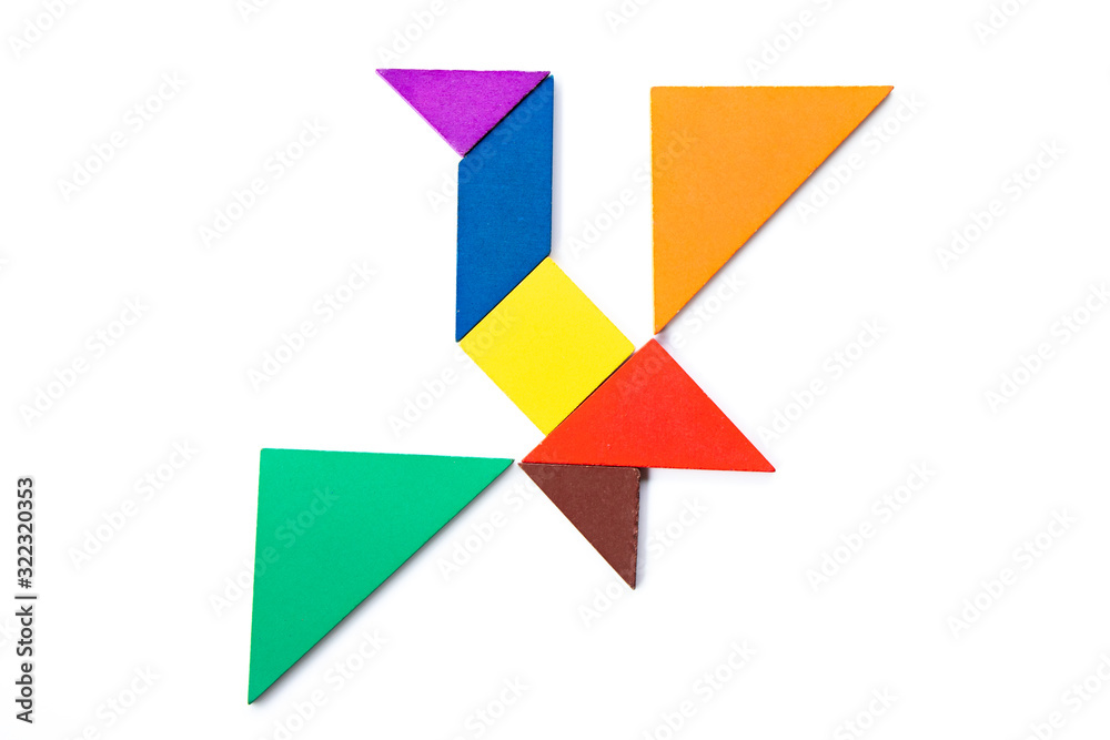 Color wood tangram puzzle in flying bird shape on white background Color wood tangram puzzle in flying bird shape on white background