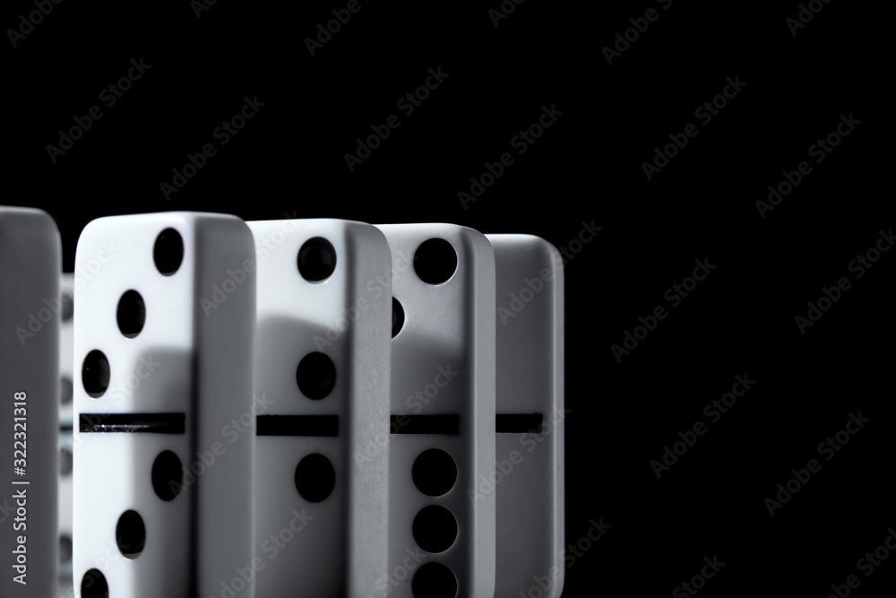 Dominoes standing in a row on black background Dominoes standing in a row on black background