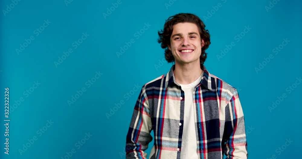 Front view of stylish man laughing and looking at camera isolated on blue background Front view of stylish man laughing and looking at camera isolated on blue background