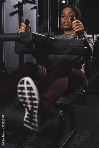 selective focus of african american girl working out on gym machine