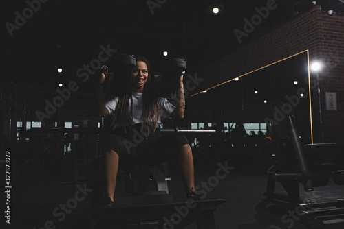 tattooed african american girl working out on gym machine © LIGHTFIELD STUDIOS