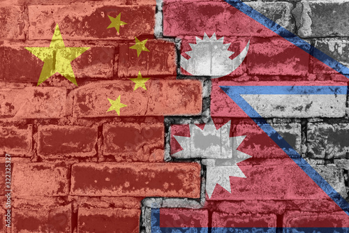 Chinese and Nepalese flag against a brick wall