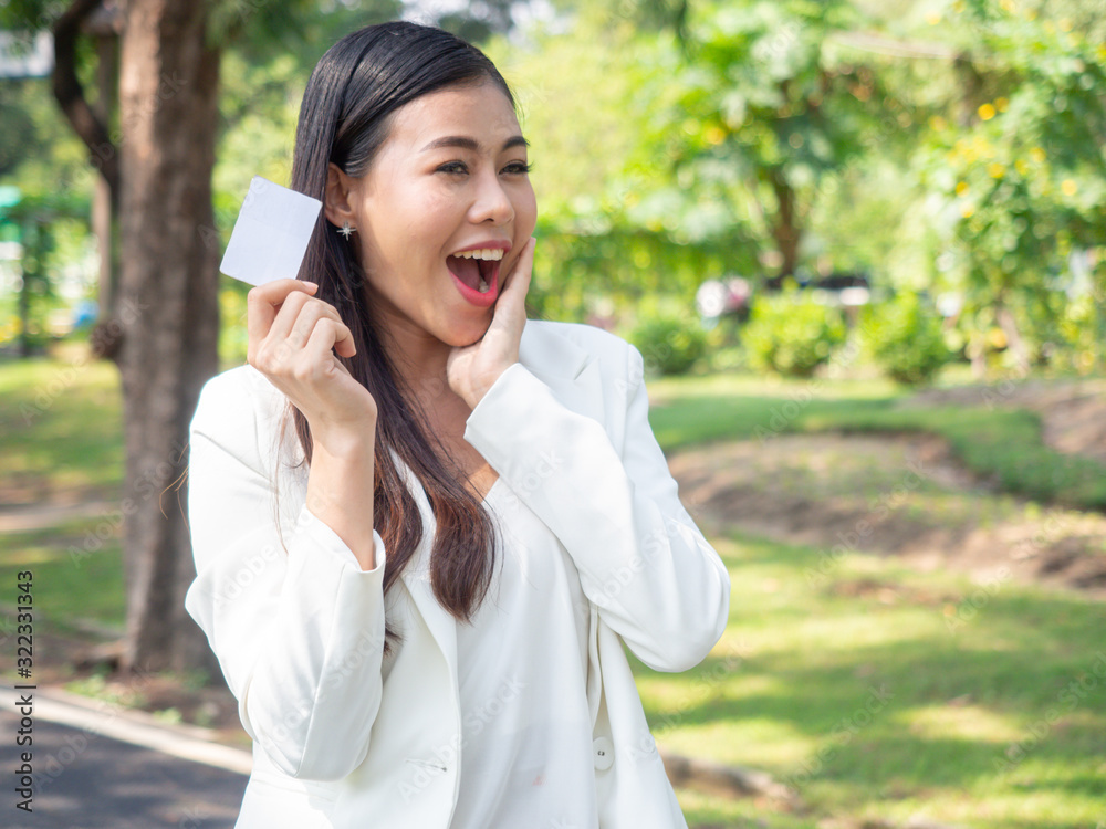 asia happy business woman holding blank card stand in park