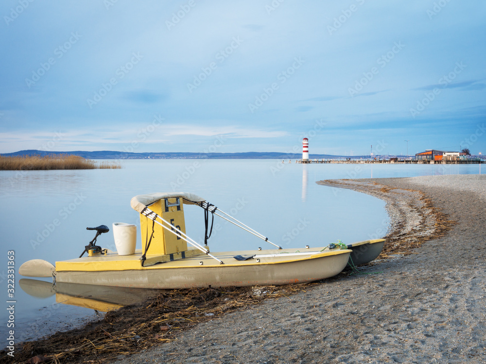 Fototapeta premium Boat and lighthouse at podesdorf at neusiedlersee in Burgenland
