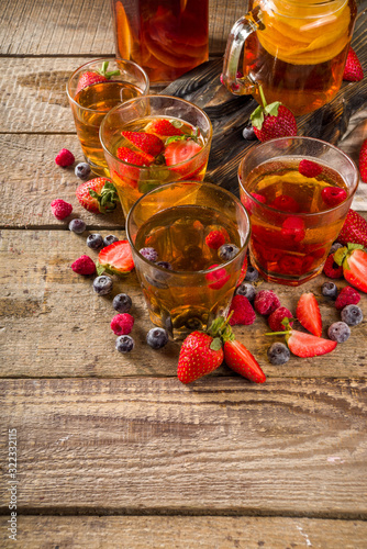 Sweet homemade fermented Kombucha drink. Kombucha fruit and berry tea, on wooden background with fresh berries
