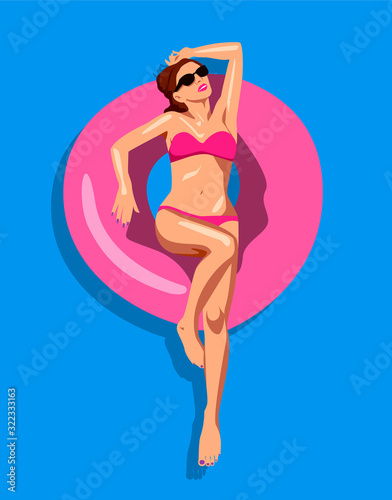 Young woman in a bikini floating on inflatable raft in a pool
