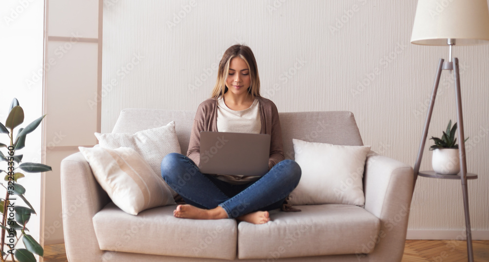 Young woman chatting with friend on laptop at home