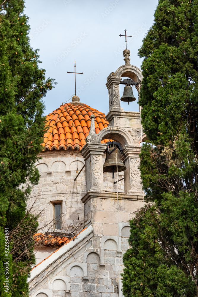 Herceg Novi / Montenegro - 05.02.2018: Ancient Byzantine-style church with a bell tower and a set of bells in the southern Adriatic.