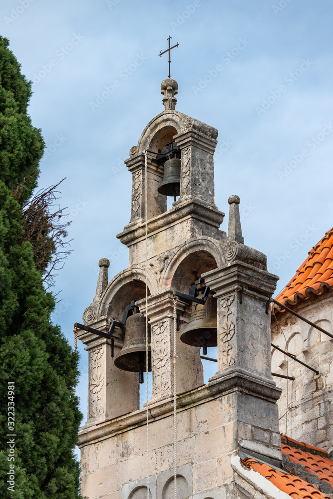 Herceg Novi / Montenegro - 05.02.2018: Ancient Byzantine-style church with a bell tower and a set of bells in the southern Adriatic.