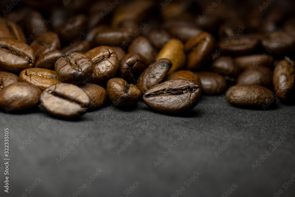 Fototapeta premium Coffee in beans on dark background. Abstract background texture.Coffee beans texture. Food background of coffee beans
