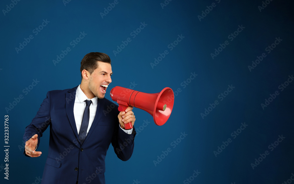 Handsome man with megaphone on blue background Handsome man with megaphone on blue background