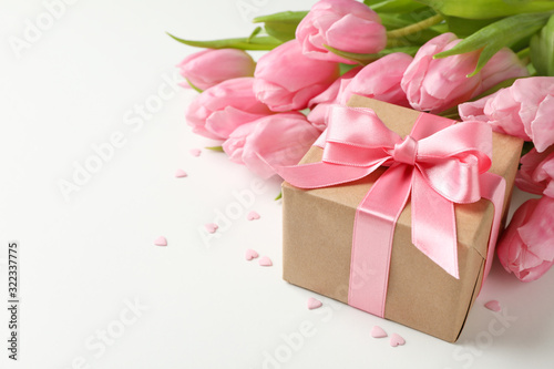 Bouquet of tulips, gift box and small hearts on white background, space for text © Atlas