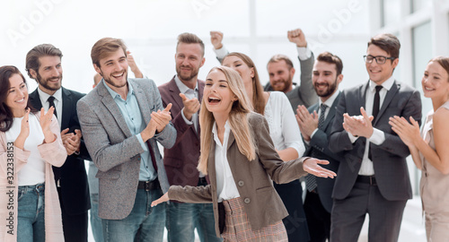 happy young woman standing in front of her jubilant colleagues