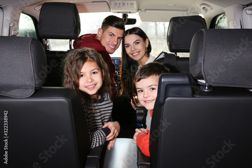 Happy family with little children inside modern car © New Africa
