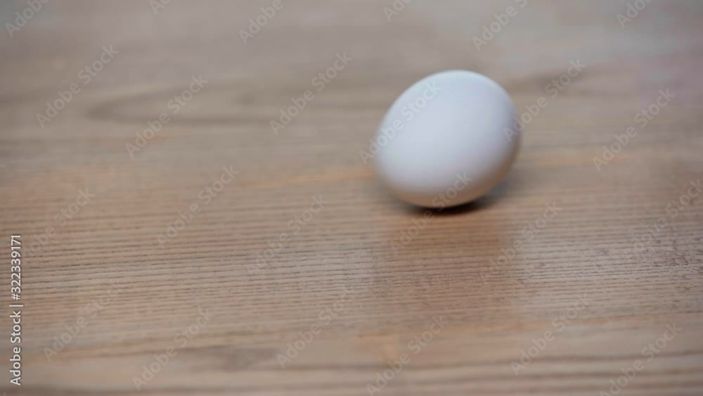 cropped view of man spinning egg on table