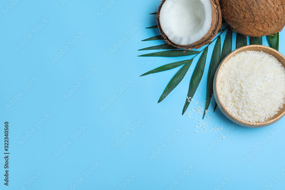 Flat lay composition with fresh coconut flakes on light blue background. Space for text Flat lay composition with fresh coconut flakes on light blue background. Space for text